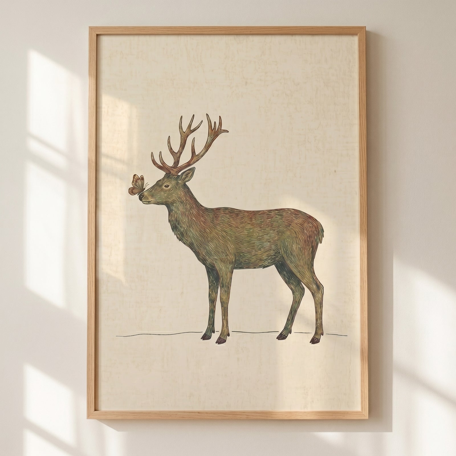 Butterfly nose woodland buck wall art in a light wood frame against a beige wall with soft window shadows.