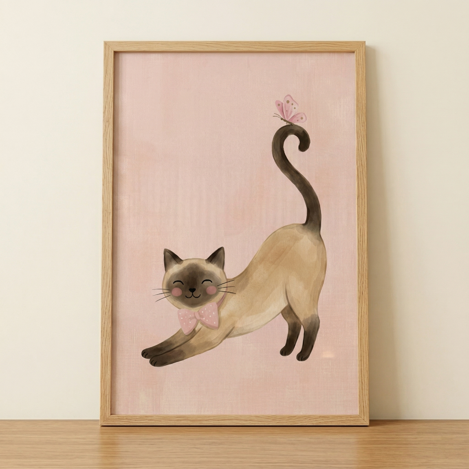 A vertical framed illustration of a stylized Siamese cat is centered against a soft pink, textured background. The cat has dark chocolate brown points on its face, ears, and paws, with a cream-colored body. It is depicted in a playful stretching pose, with its front legs extended forward and its hind legs tucked under. The cat has a cheerful expression with closed, happy eyes, thin whiskers, and soft pink blushing cheeks. 