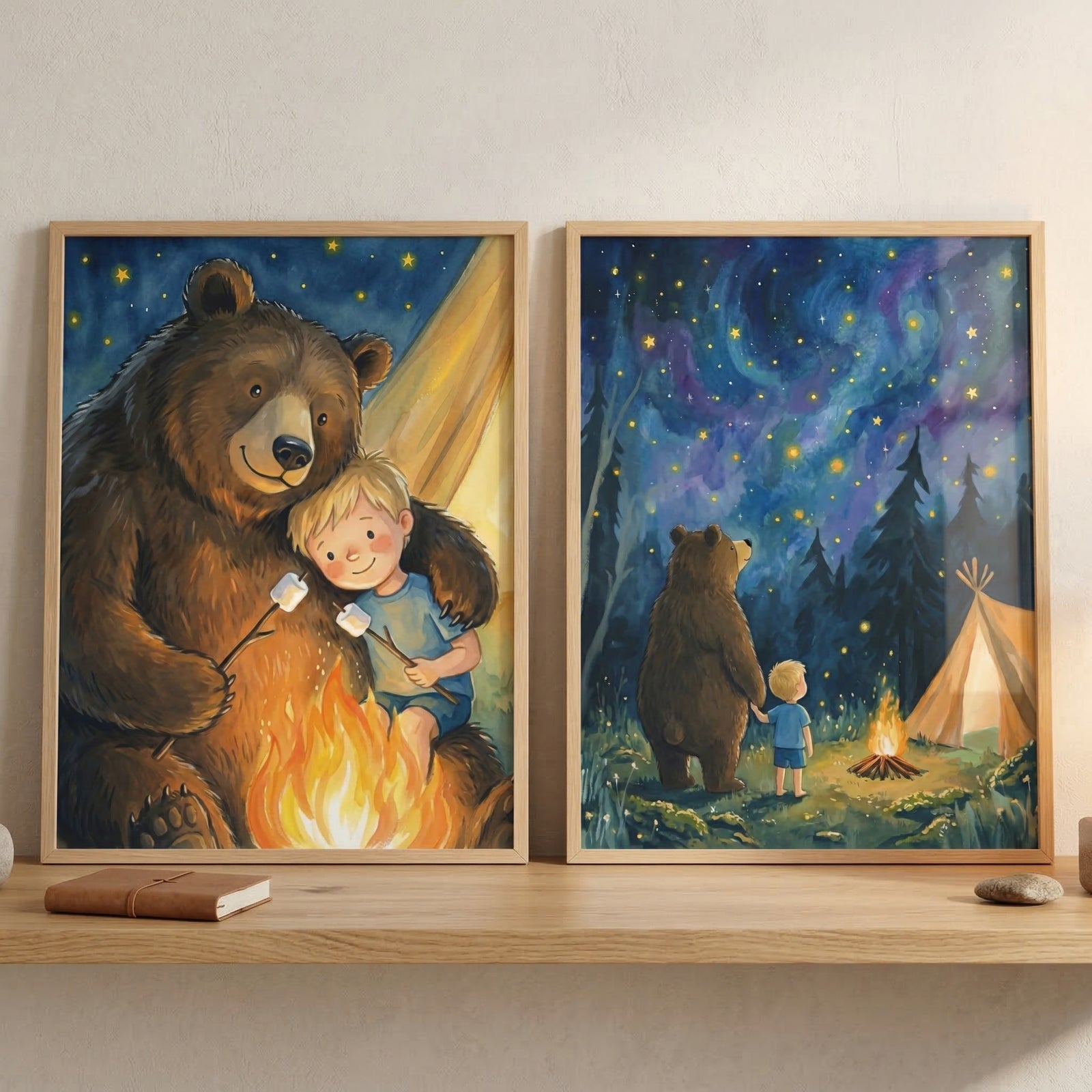 This image shows two framed illustrations displayed on a light-colored wall above a wooden shelf.
The illustration on the left depicts a large, friendly brown bear and a small, blonde-haired boy sitting together by a glowing campfire. The bear has a gentle arm around the child as they both hold sticks with marshmallows, roasting them over the vibrant flames. A tent and a dark blue sky with many yellow stars are visible in the background.
