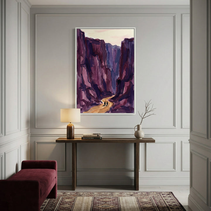 Large western-style art print of riders in a desert canyon, with exaggerated purple cliffs and a golden trail, displayed in an elegant hallway. The scene captures the vastness and rugged beauty of the desert West.