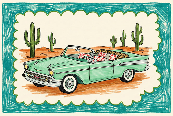 Illustrated drawing of a mint green vintage convertible car parked in a desert landscape with tall green cacti in the background. The car is filled with patterned pillows, including red stars and leopard print, and the scene is framed with a playful teal and scalloped border.