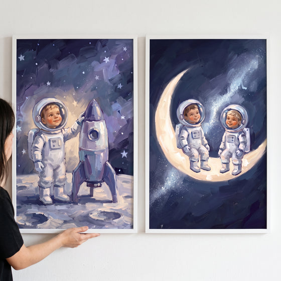 Celestial theme baby astronaut wall art set of 2 featuring children in space suits with a rocket and on a crescent moon.