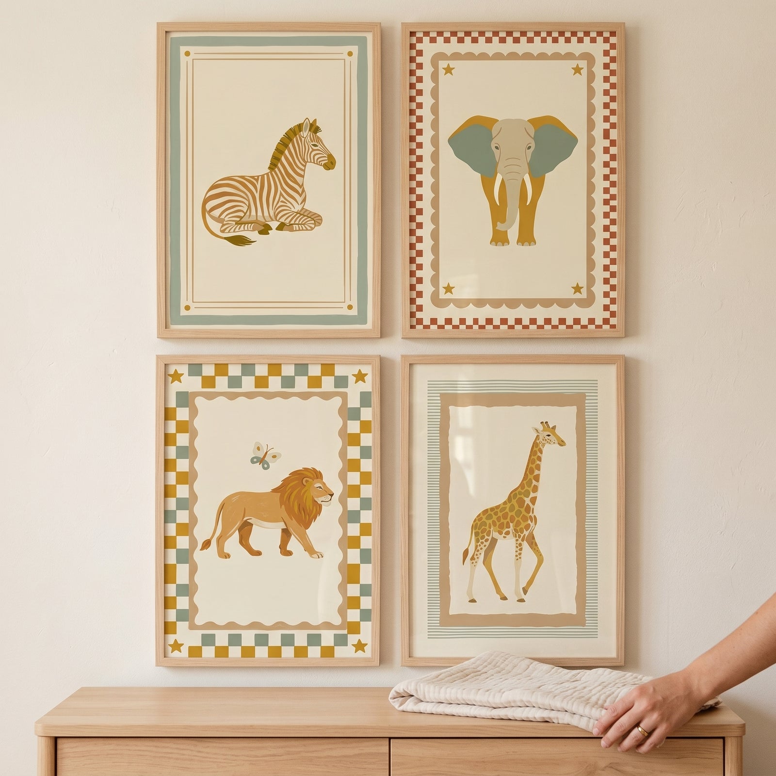 Checkered border safari animal wall art set of 4 featuring a zebra, elephant, lion, and giraffe above a wooden dresser.