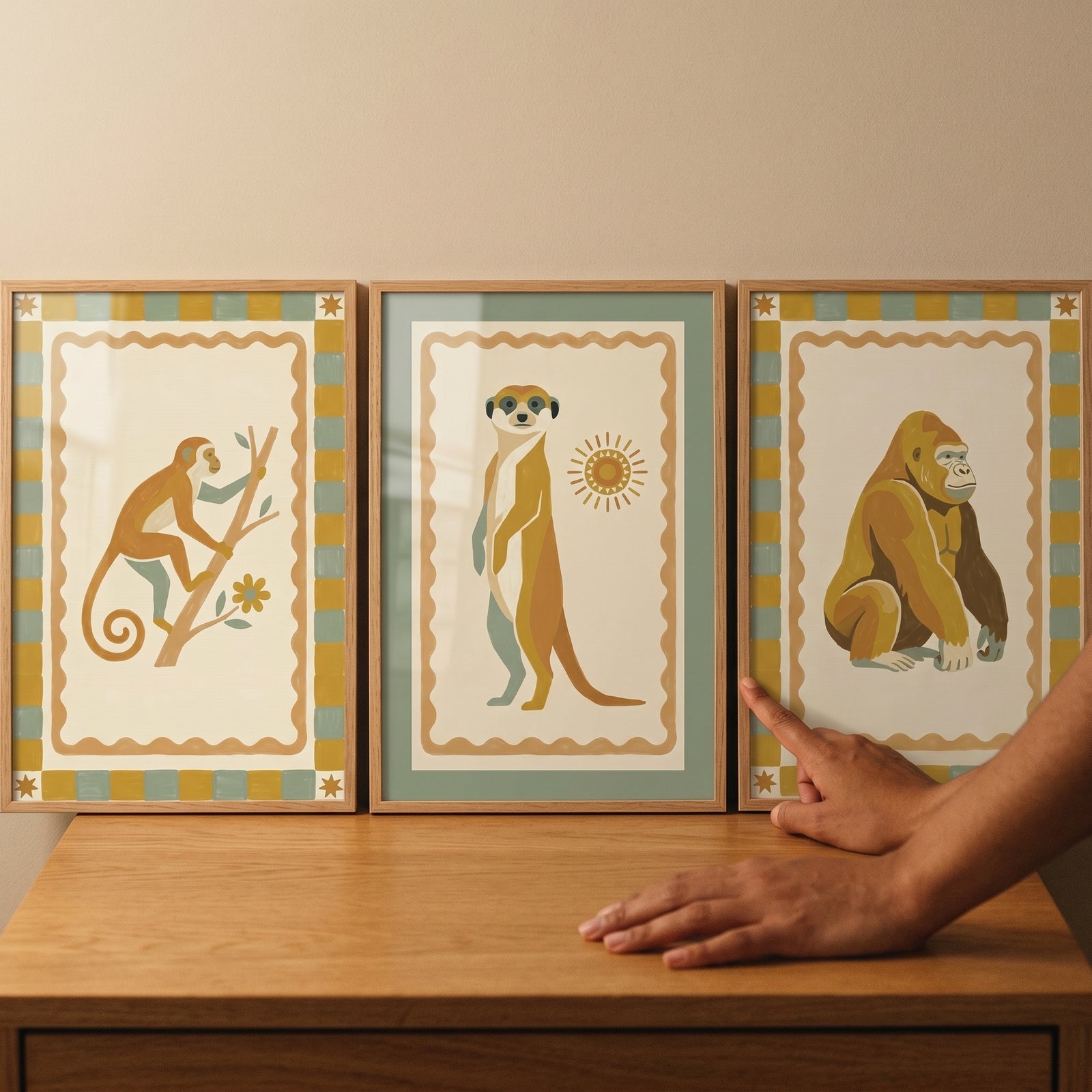 Checkered folk safari animal artwork set of 3 features a monkey, meerkat, and gorilla as a person touches a wood frame.