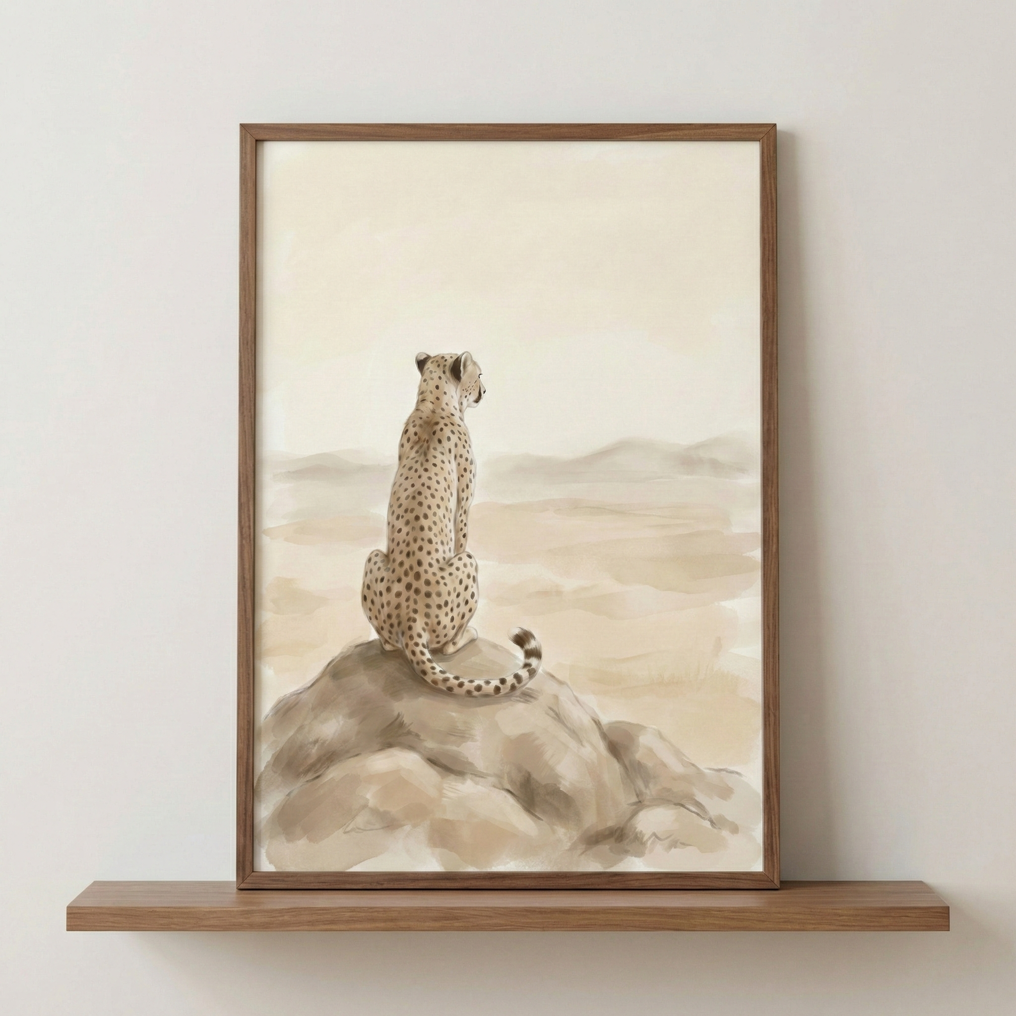 An earthy-toned framed artwork depicts a cheetah sitting on a large rock, looking out over a vast, minimalist desert landscape. The animal is shown from behind, its spotted coat and long, curved tail rendered in warm browns and tans against a hazy, atmospheric background of soft, rolling hills. 

