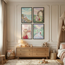 A cozy, light-filled child's nursery featuring four framed illustrations of Jesus Christ and a young girl. The art, arranged in a grid on a wall with decorative molding, shows them in various peaceful settings: by the ocean, near a flowery arch, in a meadow by a stream, and Jesus placing a flower crown on the girl's head. Below the art is a light-wood dresser with a lamp and wooden toys. A soft rug, a small chair, and a canopied bed with plush toys complete the serene room.