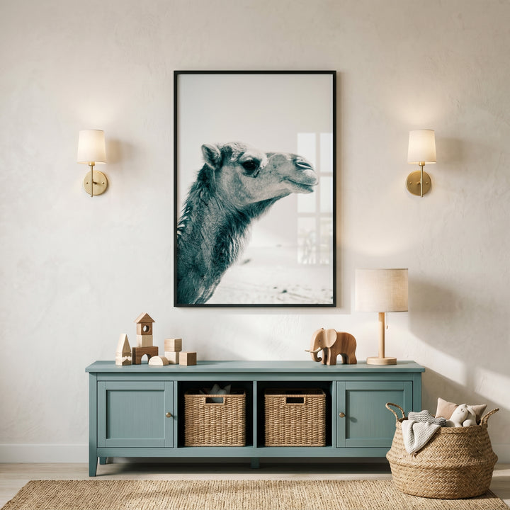 Close up profile camel wall art hangs above a blue sideboard with wooden toys and wicker baskets in a neutral room.