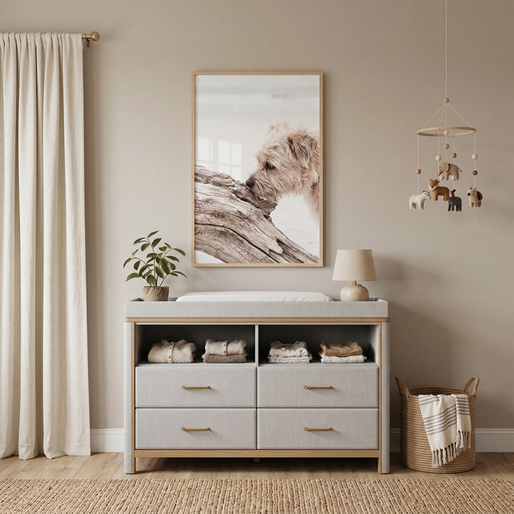 Coastal driftwood dog wall art above a gray nursery changing table with a wooden mobile and wicker basket.