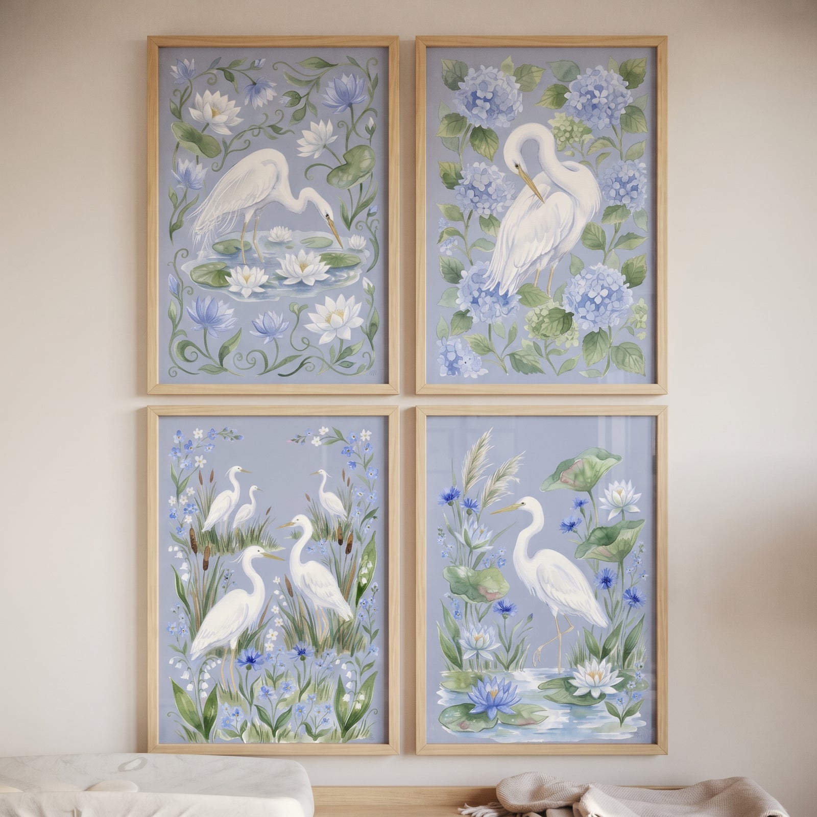 Coastal floral white heron bird wall art set of 4 with blue hydrangeas and lily pads in light wood frames.