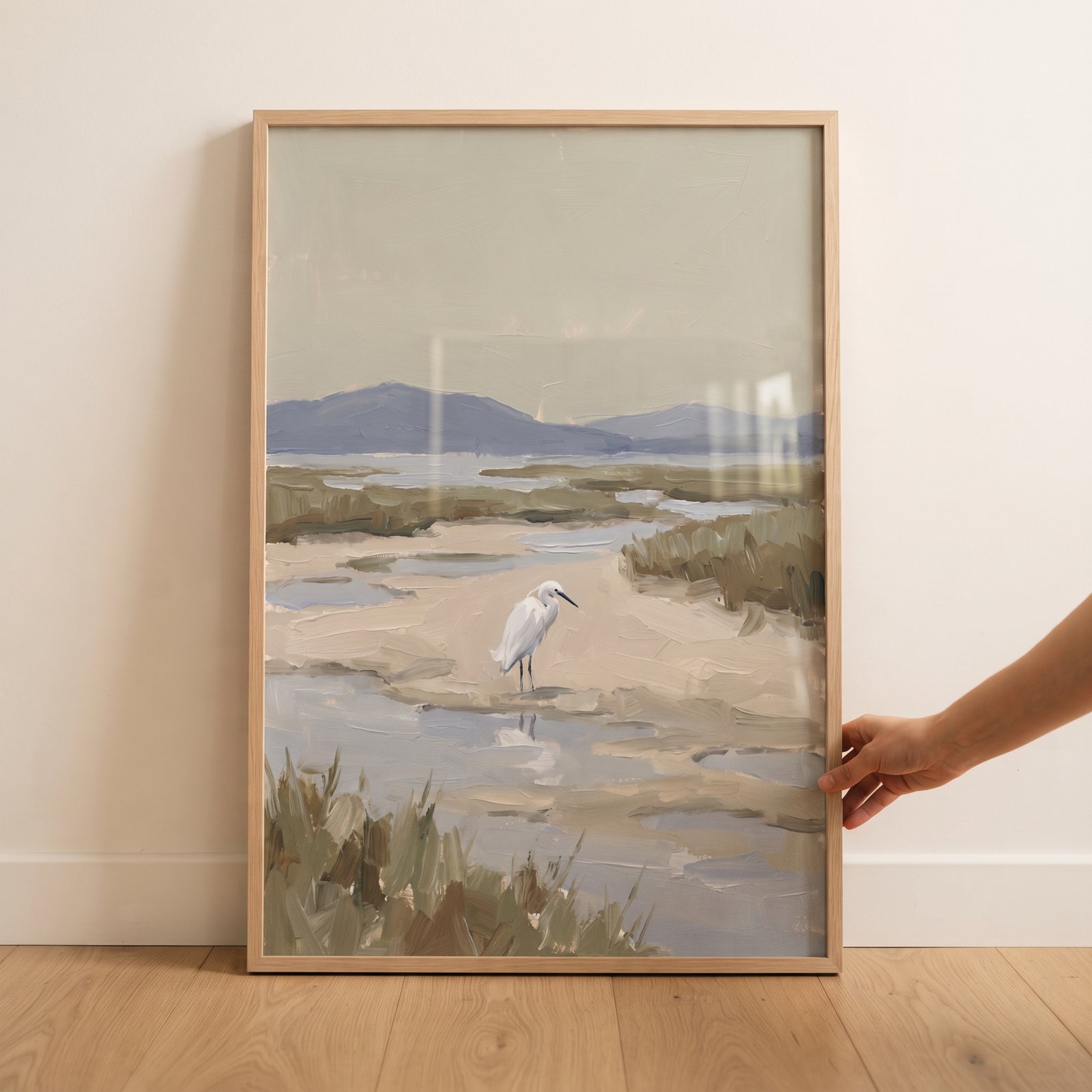 Framed coastal marsh snowy egret bird wall art showing a white bird in a wetland with grass and distant hills.