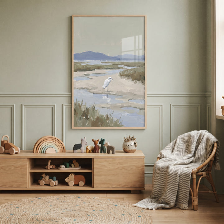 Coastal marsh snowy egret bird wall art hangs in a sage green room with wooden toys and a wicker chair.
