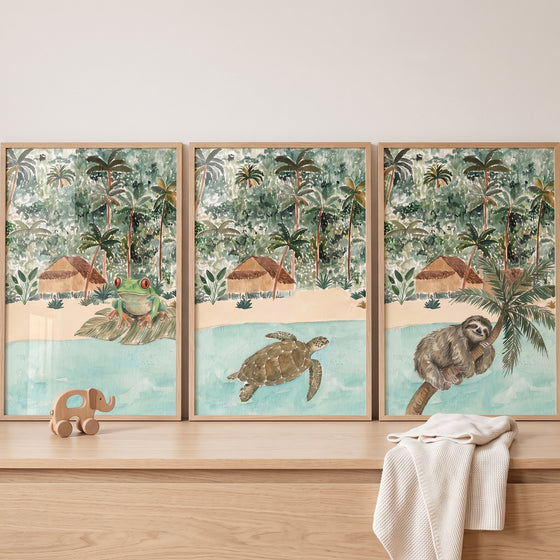 Coastal retreat jungle animals wall art set of 3 features a frog, sea turtle, and sloth in a tropical beach scene.