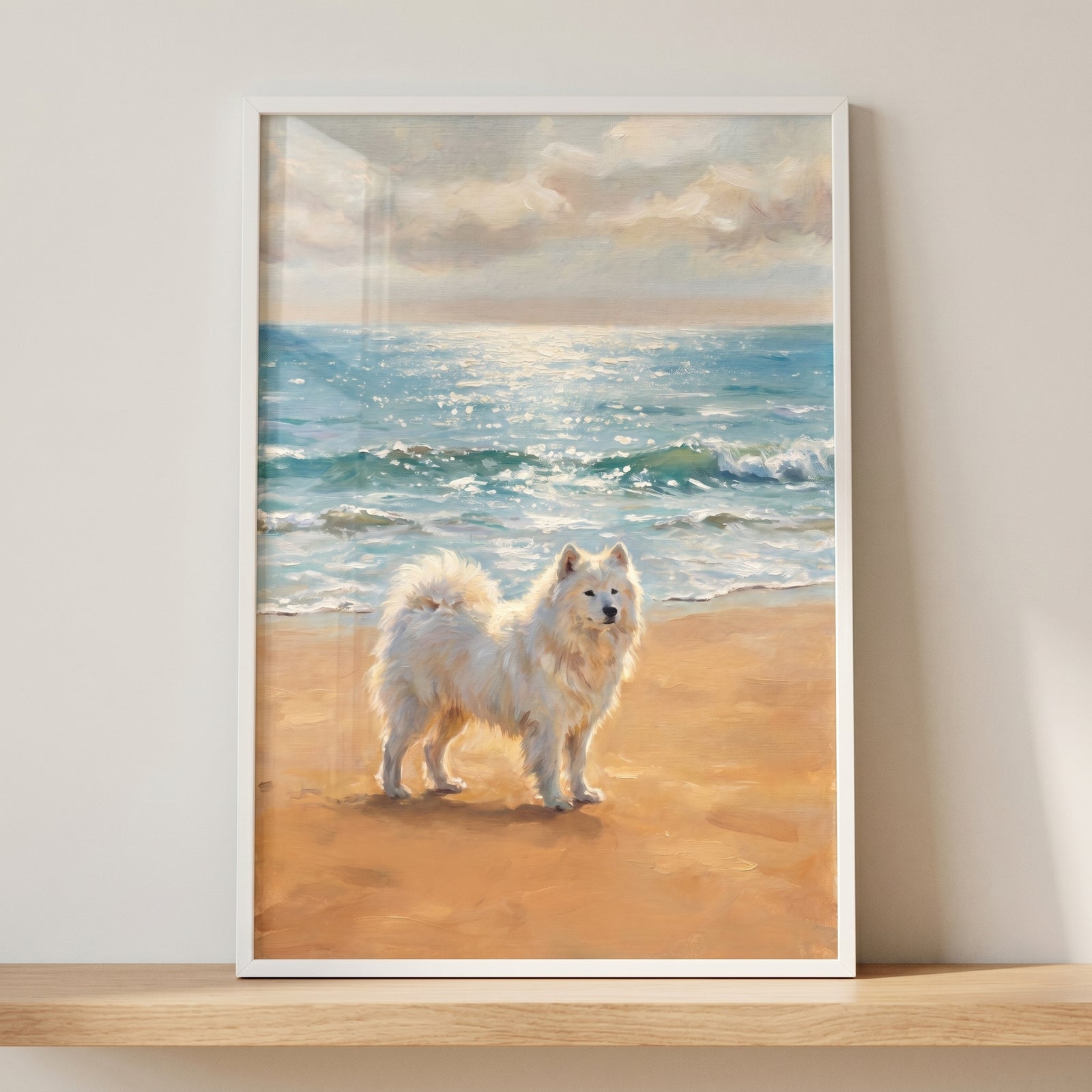 Coastal sandy beach samoyed dog wall art in a white frame on a shelf shows a fluffy white dog on a shore by ocean waves.