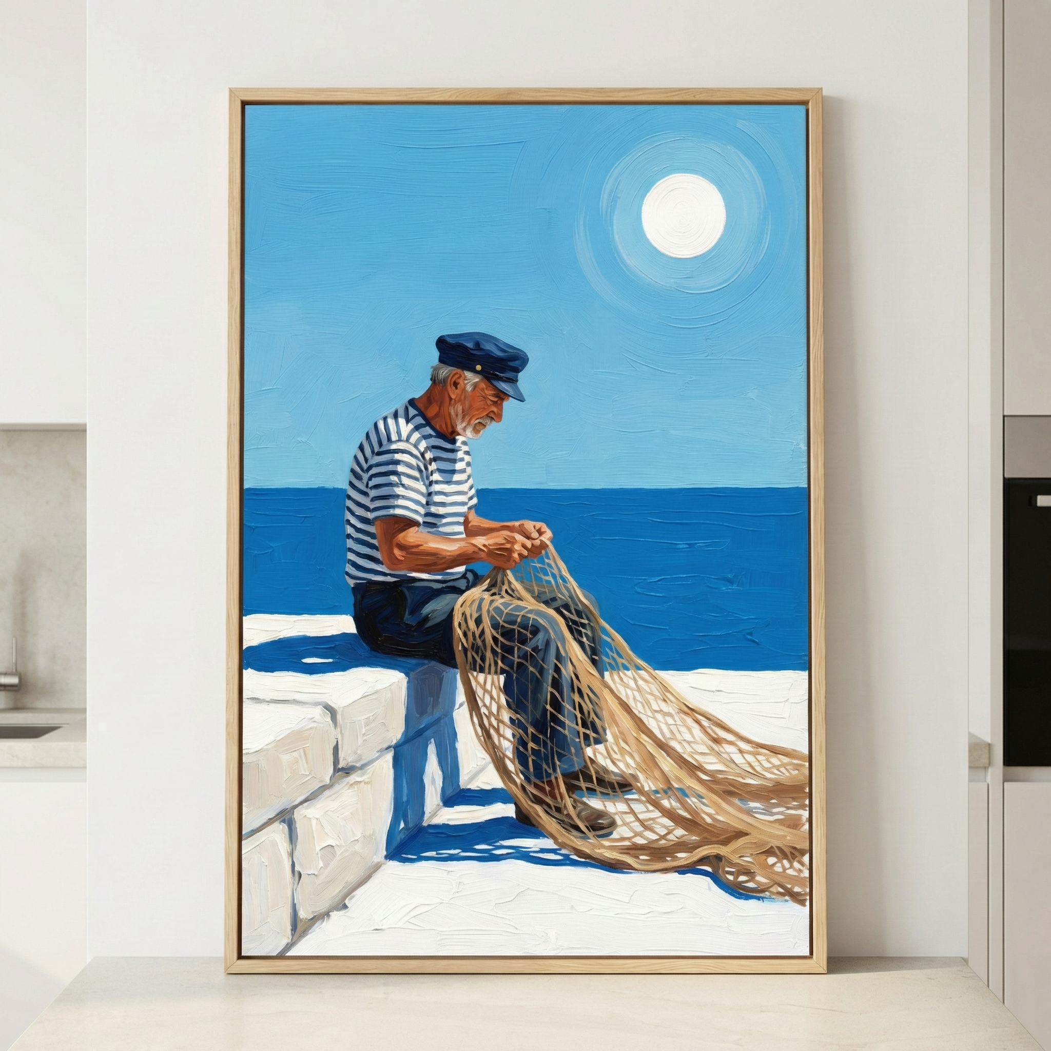 A vertically oriented artwork framed in light wood depicts an elderly fisherman sitting on a white stone ledge by the sea. He wears a blue and white striped short-sleeved shirt, dark pants, and a dark blue sailor cap. His head is bowed as he meticulously works on a large, tan-colored fishing net that drapes over his knees and onto the ground. The background features a deep blue ocean meeting a bright blue sky. A large, white, luminous sun shines high in the sky, surrounded by concentric circles of light. 