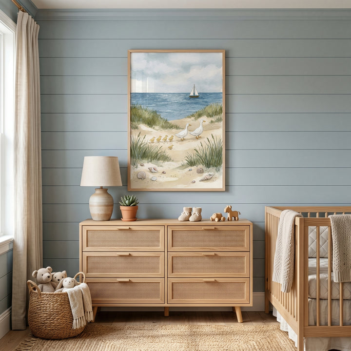 Blue nursery with a light wood dresser, a crib, and coastal watercolor duck family wall art on a shiplap wall.