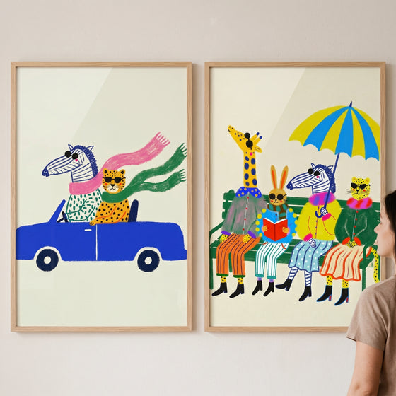 Cool shades safari animal wall art set of 2 with animals wearing sunglasses in a blue car and on a park bench.
