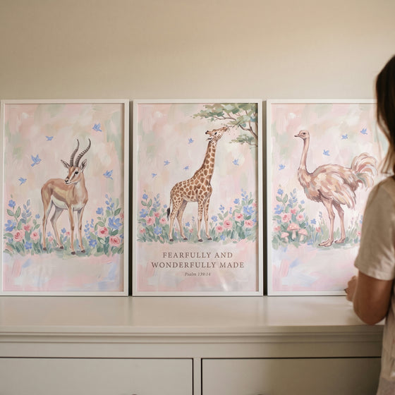 Cottagecore garden safari animals wall art set of 3 with a gazelle, giraffe, and ostrich in soft floral landscapes.