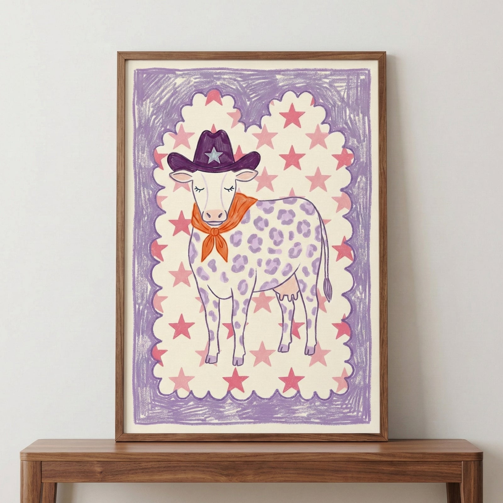 Playful illustration of a cow with purple spots wearing a western-style hat with a star and an orange bandana, framed with a whimsical purple and pink star border.