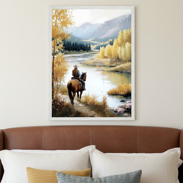 Bedroom with a brown leather headboard. A framed painting of a cowboy on horseback by a river with yellow autumn trees and mountains, in a textured style, hangs centered above the bed.