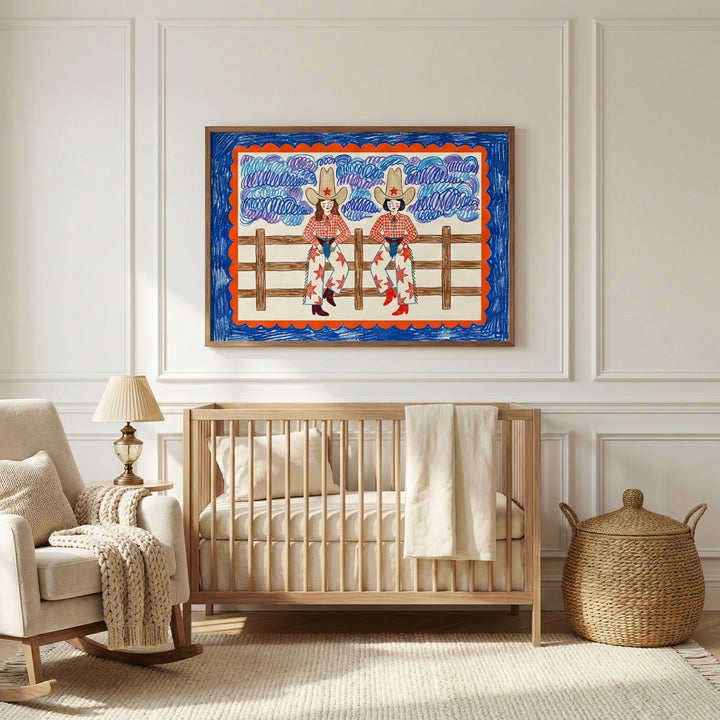 Framed wall art of two cowgirls in red checkered shirts, star-covered chaps, and tall cowboy hats, hanging above a natural wood crib in a softly lit nursery. This playful western-themed wall art adds a bold, imaginative accent to kids’ room decor.