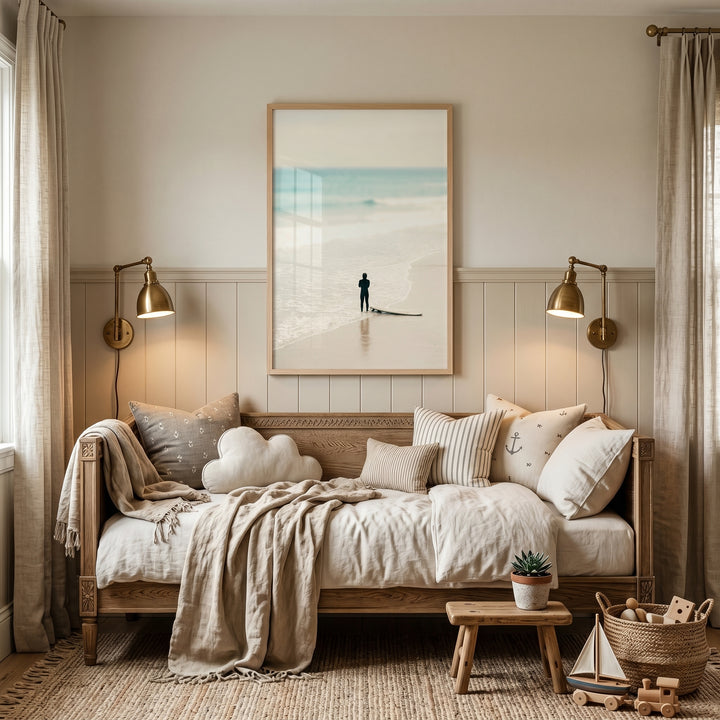 Creamy neutral minimalist surfer wall art above a daybed with brass lamps, wooden toys, and a textured jute rug.