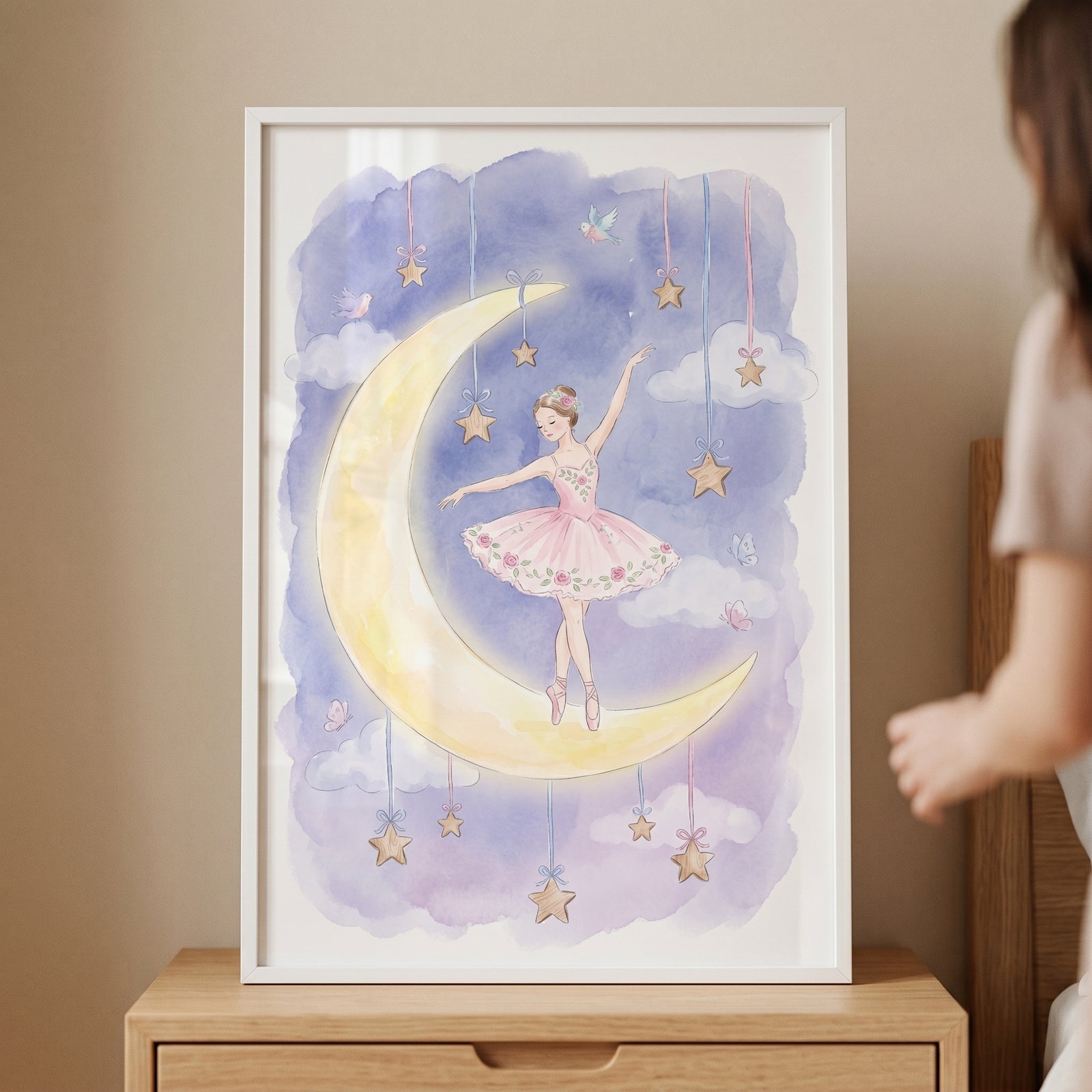 Crescent moon ballerina wall art featuring a girl in a pink tutu on a yellow moon among purple clouds and hanging stars.