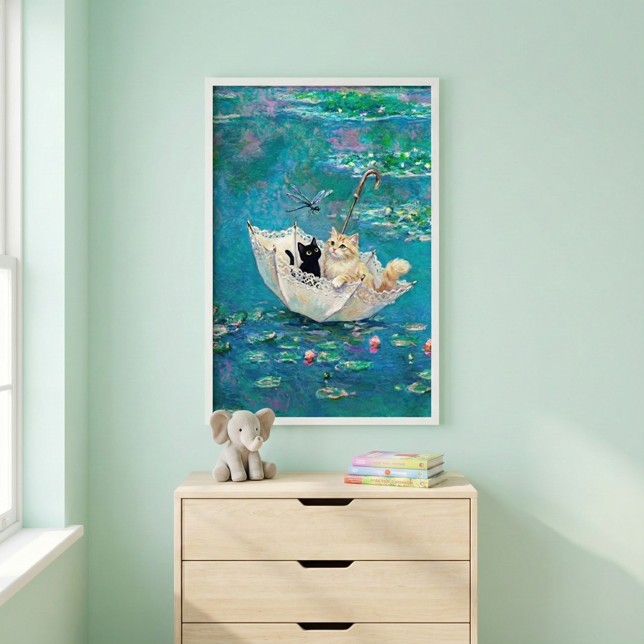 Whimsical cat-themed painting displayed above a dresser in a mint green room. The artwork shows two cats inside an umbrella drifting on a pond, surrounded by lily pads and a dragonfly, blending playful charm with soft impressionist colors.