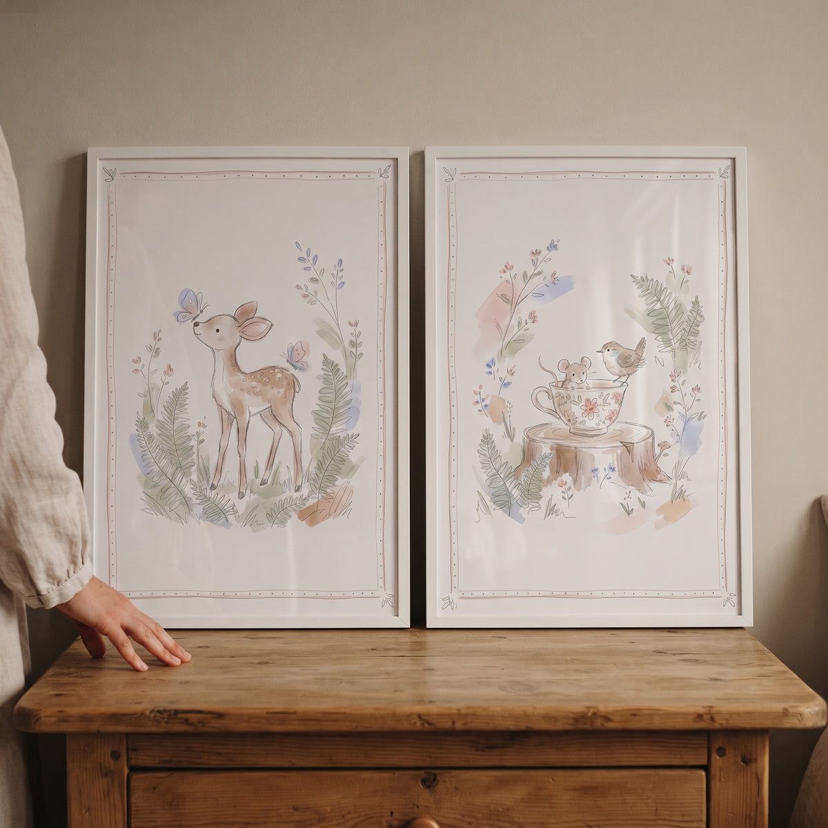 Dainty floral woodland animal wall art set of 2 featuring a fawn and a mouse in a teacup on a wooden dresser.