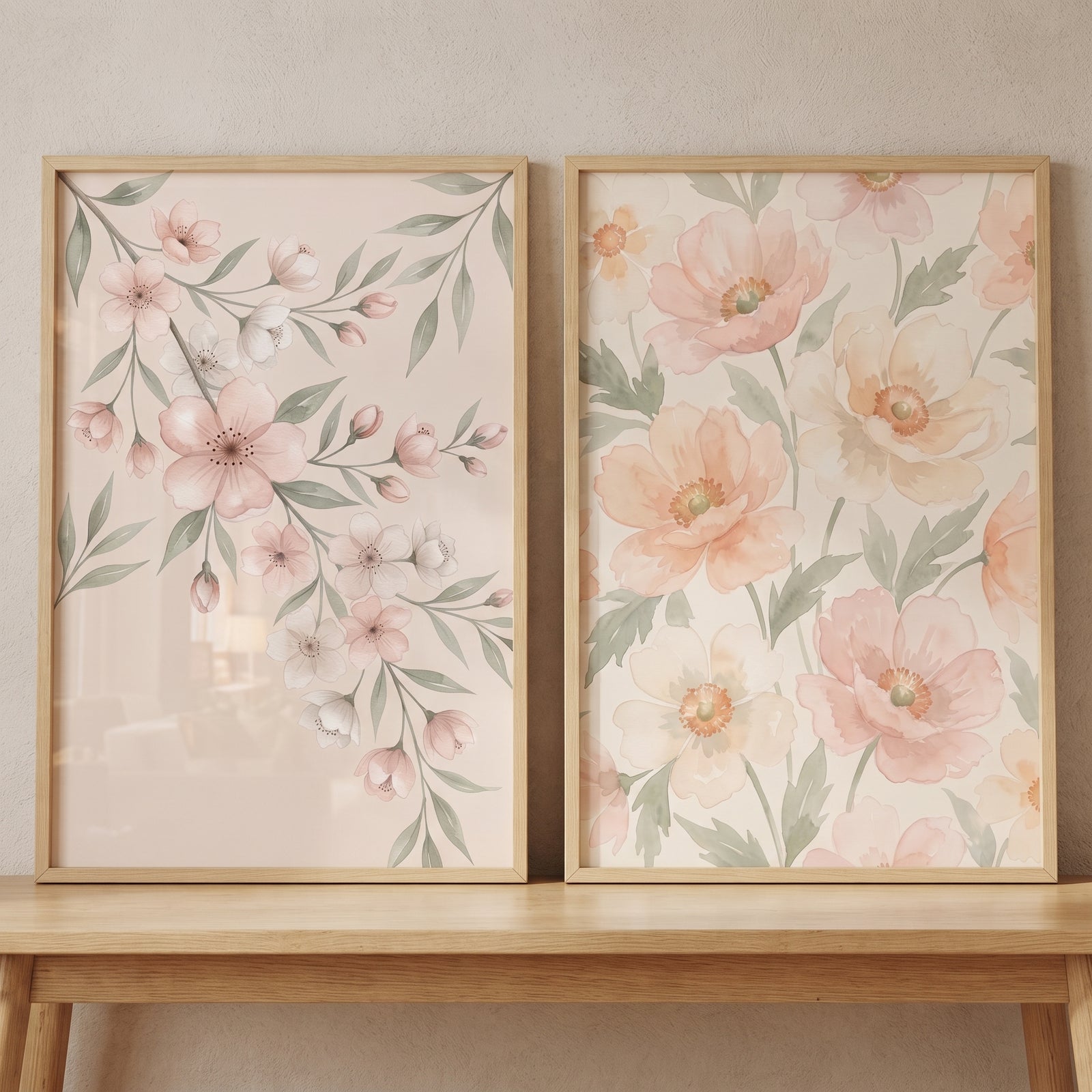 Dainty pastel floral wall art set of 2 in light wood frames, resting on a wooden table against a neutral wall.