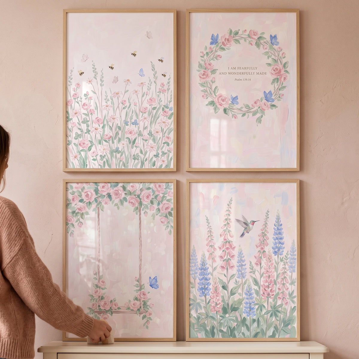 Dainty pink botanical garden artwork set of 4 with flowers, bees, and a hummingbird in light wood frames on a pink wall.