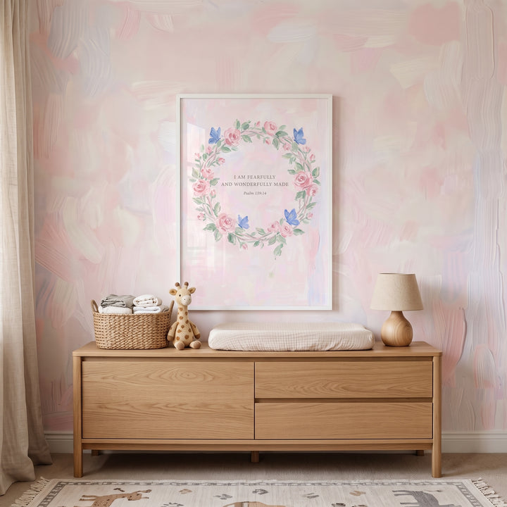 Dainty pink rose psalm bible wall art above a wooden dresser with a plush giraffe and lamp in a pink watercolor nursery.