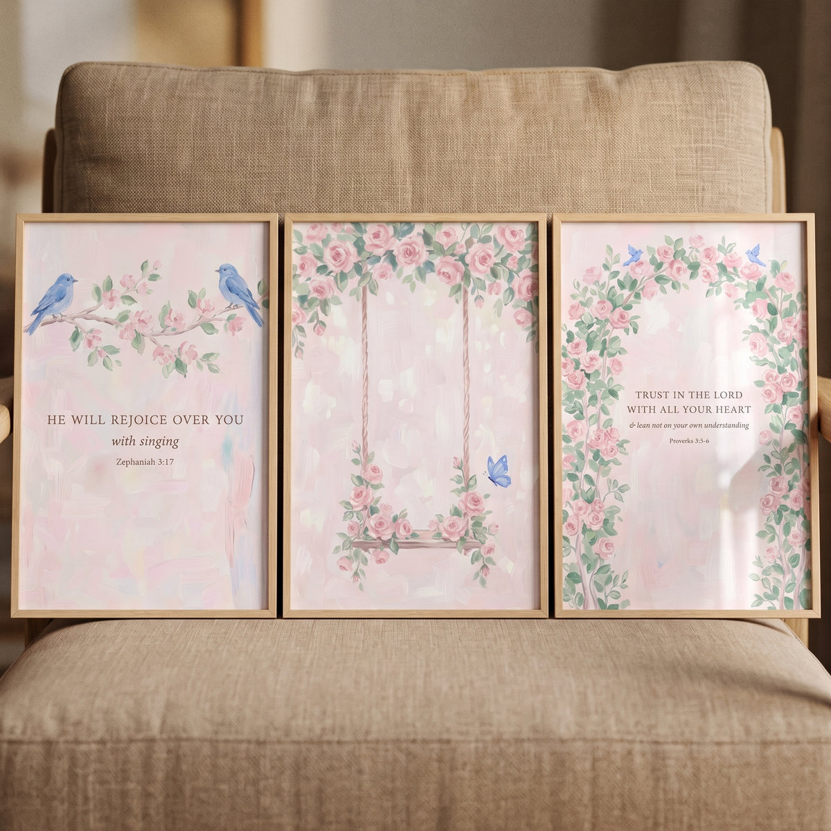 Dainty watercolor rose wall art set of 3 displays blue birds, a swing, and Bible verses in wood frames on a beige chair.