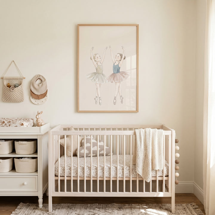 Dancing watercolor girls ballerina wall art hangs above a white crib in a neutral nursery with a matching changing table.