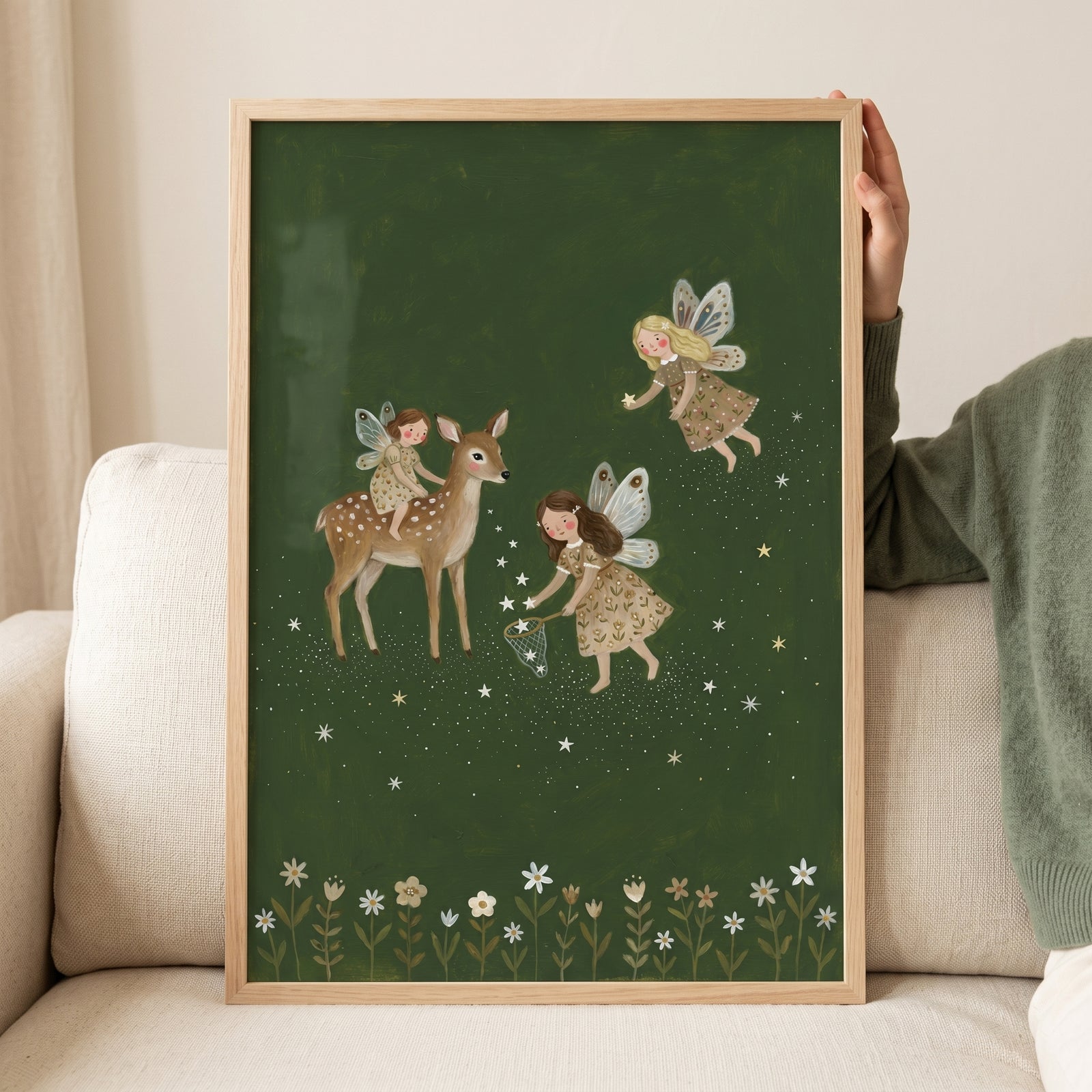 Dark green forest fairies wall art depicts three fairies and a deer catching stars above a row of white flowers.
