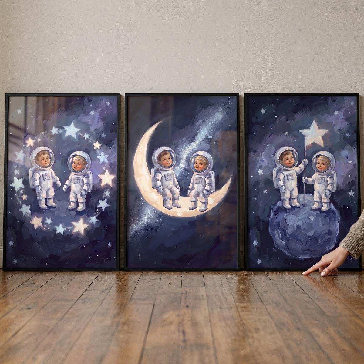 Dark indigo baby astronauts wall art set of 3 shows two explorers on a moon, a small planet, and within a star ring.