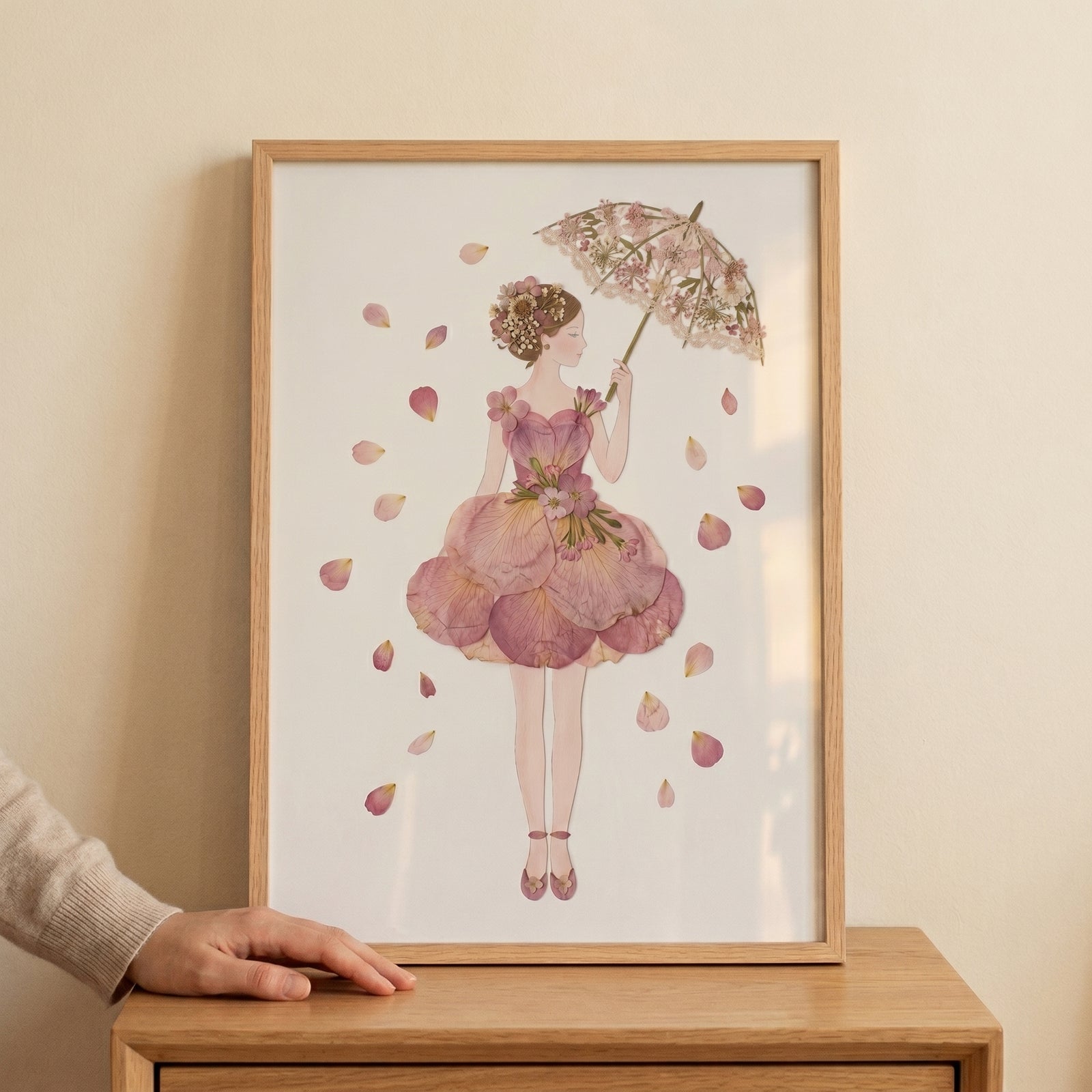 Framed delicate floral parasol lady wall art of a woman in a pink petal dress with petals falling around her.
