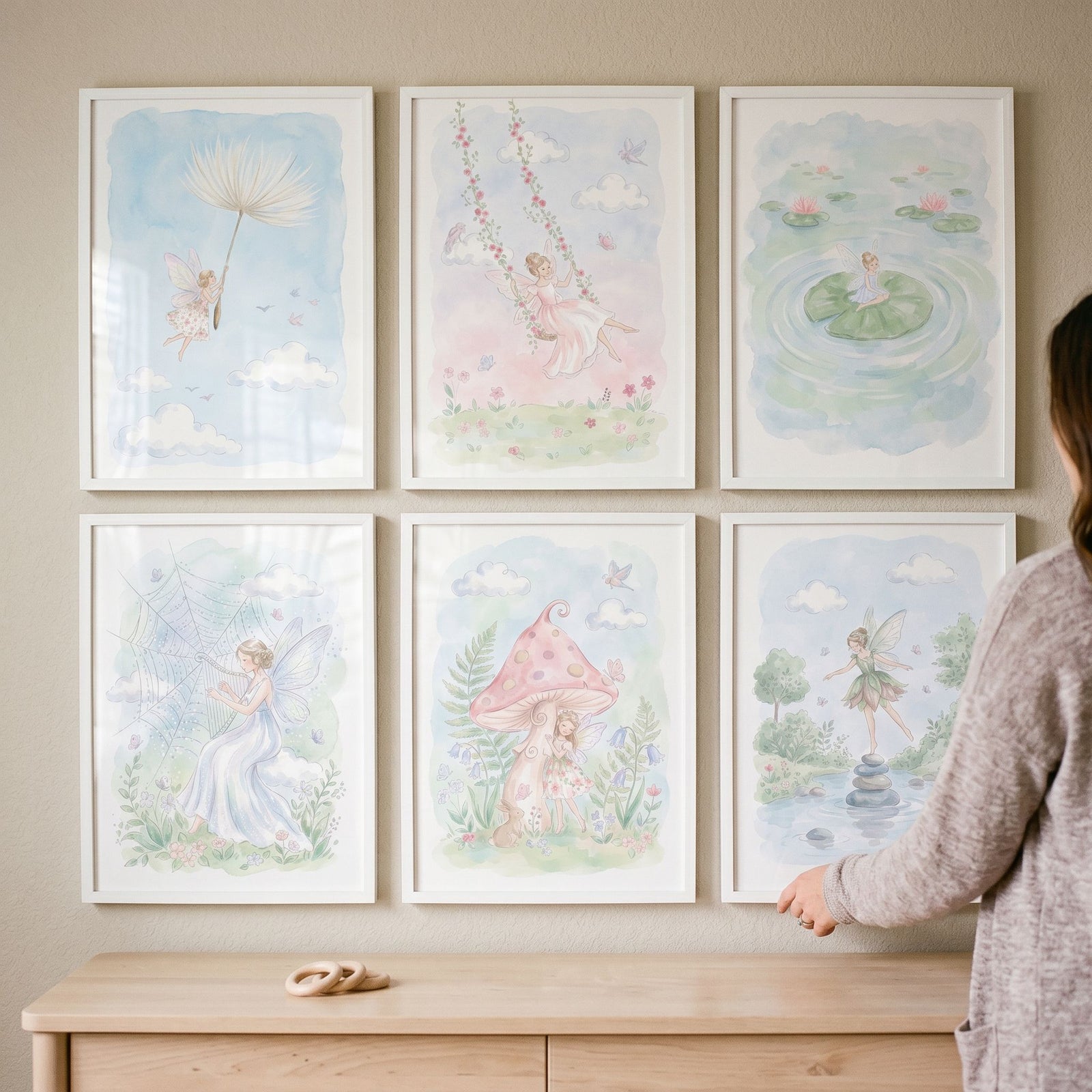 Fairies and garden scenes in a delicate garden fairy wall art set of 6 framed watercolor prints above a wooden dresser.