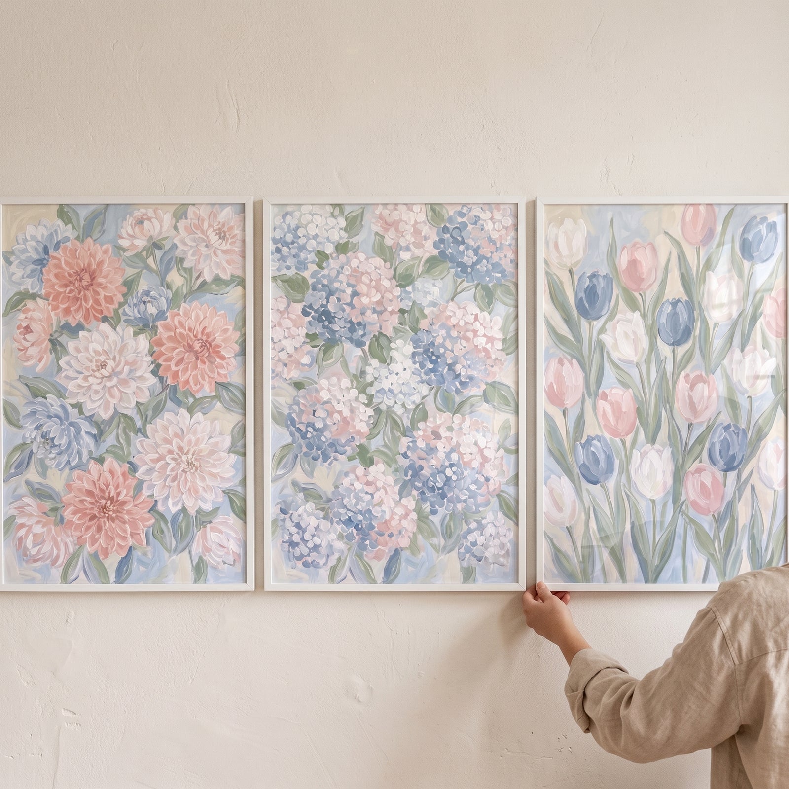 Delicate pastel garden floral wall art set of 3 featuring framed dahlias, hydrangeas, and tulips on a beige wall.