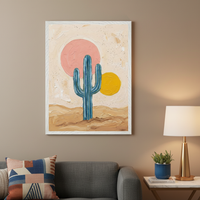Modern living room with a gray sofa. A textured painting in a white frame depicting a blue cactus, a pink sun, and a yellow sun in a desert landscape hangs above the sofa. A side table with a lamp and plant is to the right.