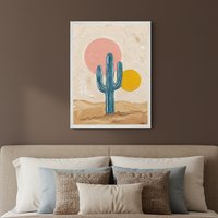 Bedroom with a beige bed and headboard. Above the bed hangs a framed textured painting of a blue saguaro cactus in a desert, with a large pink sun and a smaller yellow sun against a light background.