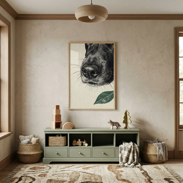 A serene, minimalist children's room is filled with soft, earthy tones. Centered on a light beige textured wall is a large, light-wood framed artwork featuring a detailed black-and-white sketch of a dog's snout and whiskers, accented by a single green leaf below it. 
