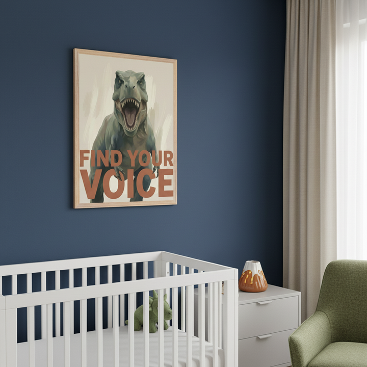 Modern nursery with a dark blue wall. A framed poster of a roaring green T-Rex with "FIND YOUR VOICE" in burnt orange text hangs above a white crib. A green dinosaur toy is in the crib. A light gray dresser with a volcano nightlight and part of an olive green armchair are also visible.