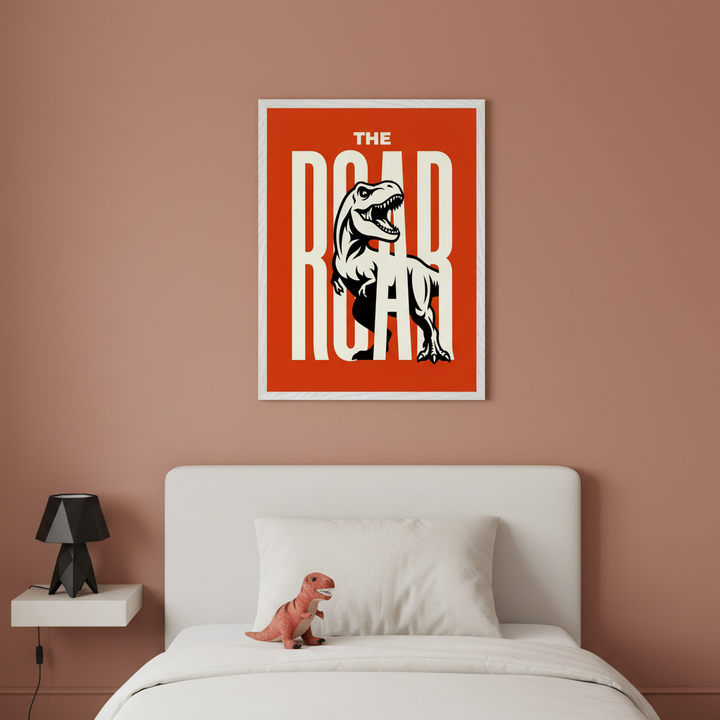 Kid's bedroom with a white bed, headboard, and floating nightstand against a terracotta wall. A framed orange poster featuring a roaring T-Rex and "THE ROAR" text in a bold graphic style hangs centered above the bed. A black geometric lamp sits on the nightstand, and a dinosaur toy is on the bed.