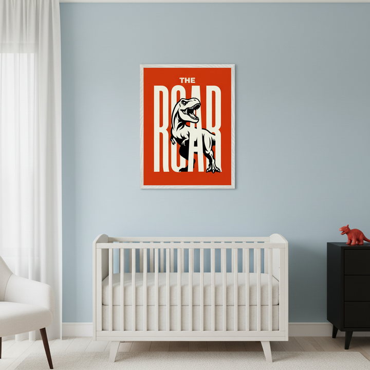 Modern nursery with a white crib and partial white armchair. A large framed poster of a roaring T-Rex on a red background with "THE ROAR" text hangs on a light blue wall, centered above the crib. A black dresser is on the right.