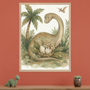 Kid's room with a light wood dresser against a terracotta orange wall. A large framed illustration of a friendly brontosaurus-like dinosaur looking at a nest with eggs and a hatching baby pterodactyl hangs above the dresser. A small green toy dinosaur is on the dresser to the left, and a potted succulent is to the right.