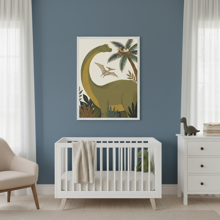 Modern nursery with a white crib, dresser, and beige armchair. A large framed illustration of a green long-necked dinosaur, a pteranodon, a palm tree with eggs, and jungle foliage hangs centered above the crib on a blue wall.
