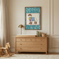 A framed illustration of a bull terrier dressed in cowboy boots and a blue checkered vest hangs above a wooden nursery dresser. The warm-toned room includes a brass lamp, a wooden rocking horse, and a cream-colored shag rug.