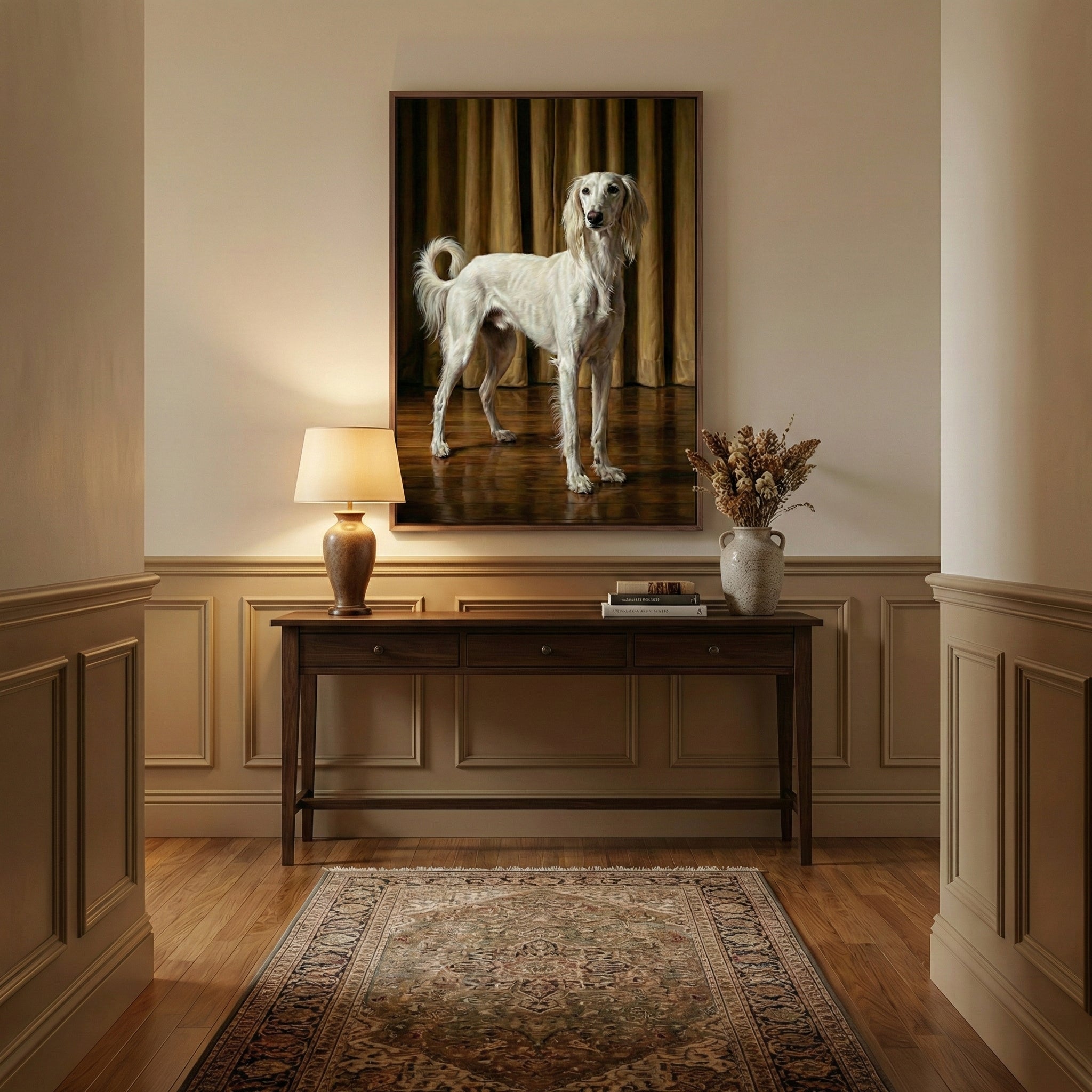 Elegant portrait of a saluki dog displayed in a warmly lit hallway, with the sighthound posed in front of floor-length curtains and a wooden console table beneath. The scene is styled with a table lamp, books, and a neutral-toned vase of dried florals.