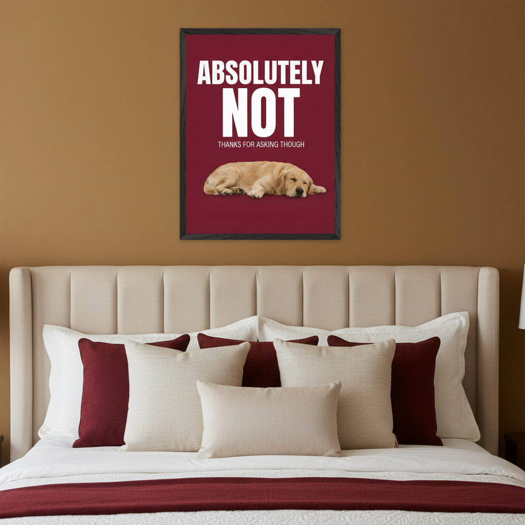 Modern bedroom with a beige upholstered bed and maroon accent pillows. Above the bed hangs a framed poster featuring white text "ABSOLUTELY NOT THANKS FOR ASKING THOUGH" and a sleeping golden retriever puppy on a maroon background.