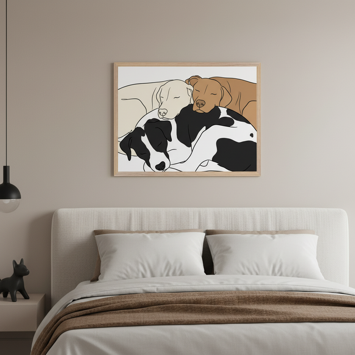 Modern bedroom with a bed and beige fabric headboard. A framed minimalist illustration of three sleeping dogs (beige, brown, black and white) hangs centered above the bed. A nightstand with a dark sculpture and a black pendant light are on the left.